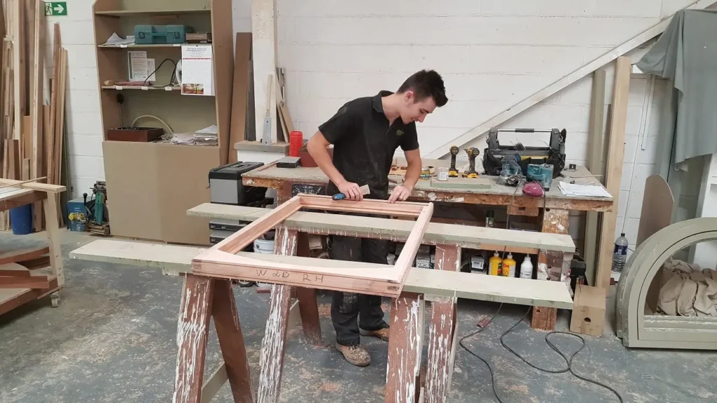 Apprentice sands a window frame