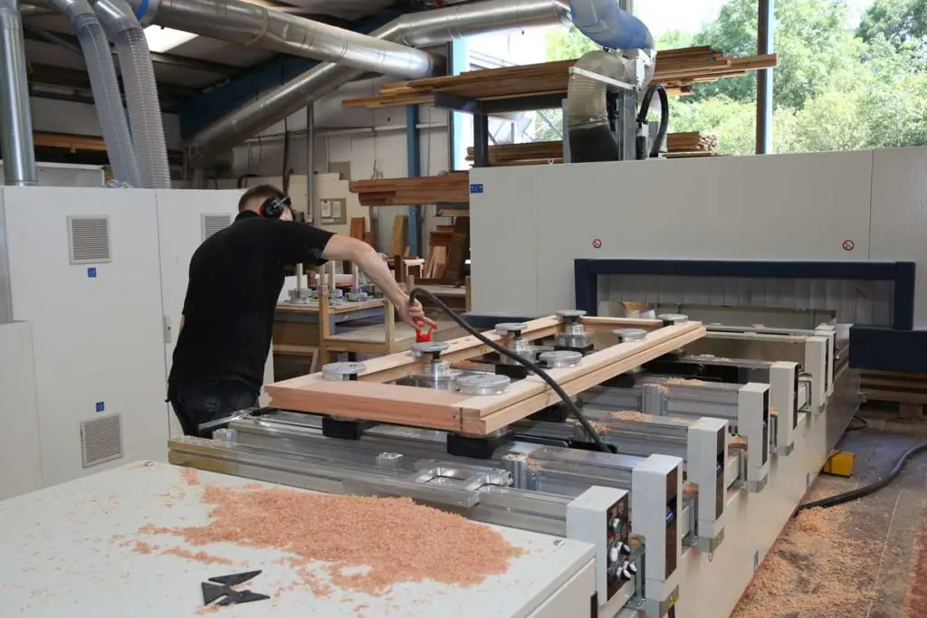 Who sells timber windows? A modern CNC router machine in a timber window manufacturers workshop where you can buy timber windows