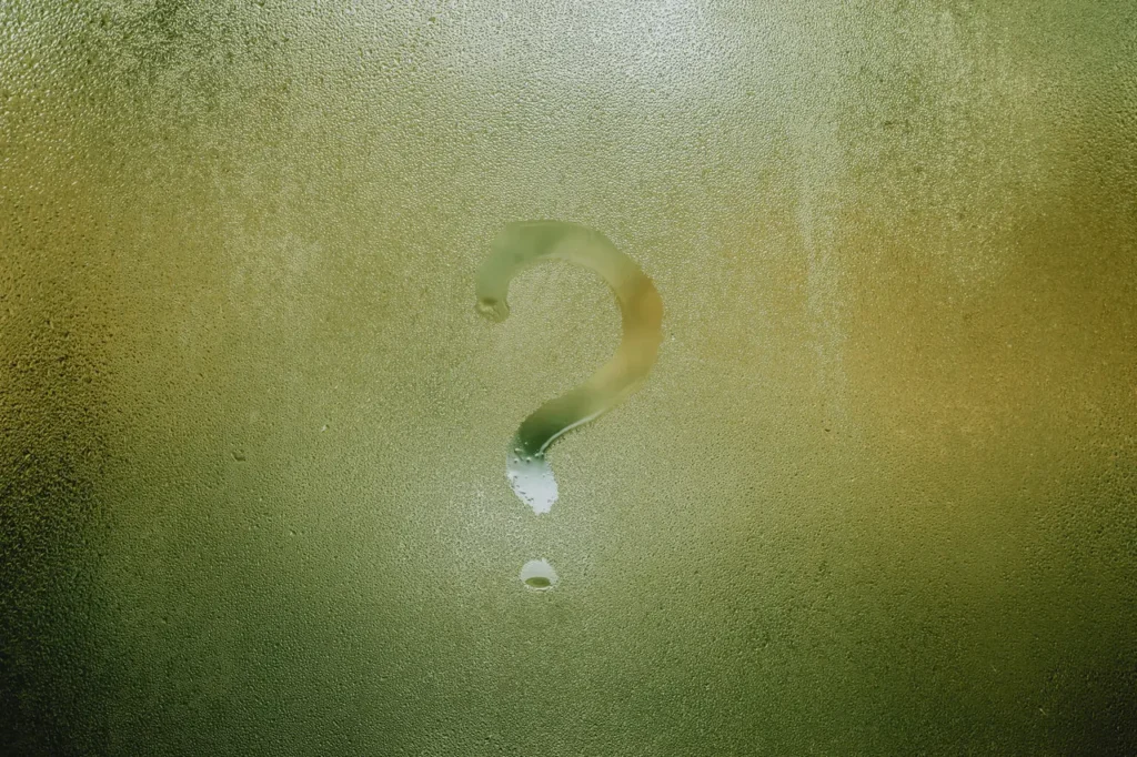 Question mark drawn in condensation on a window