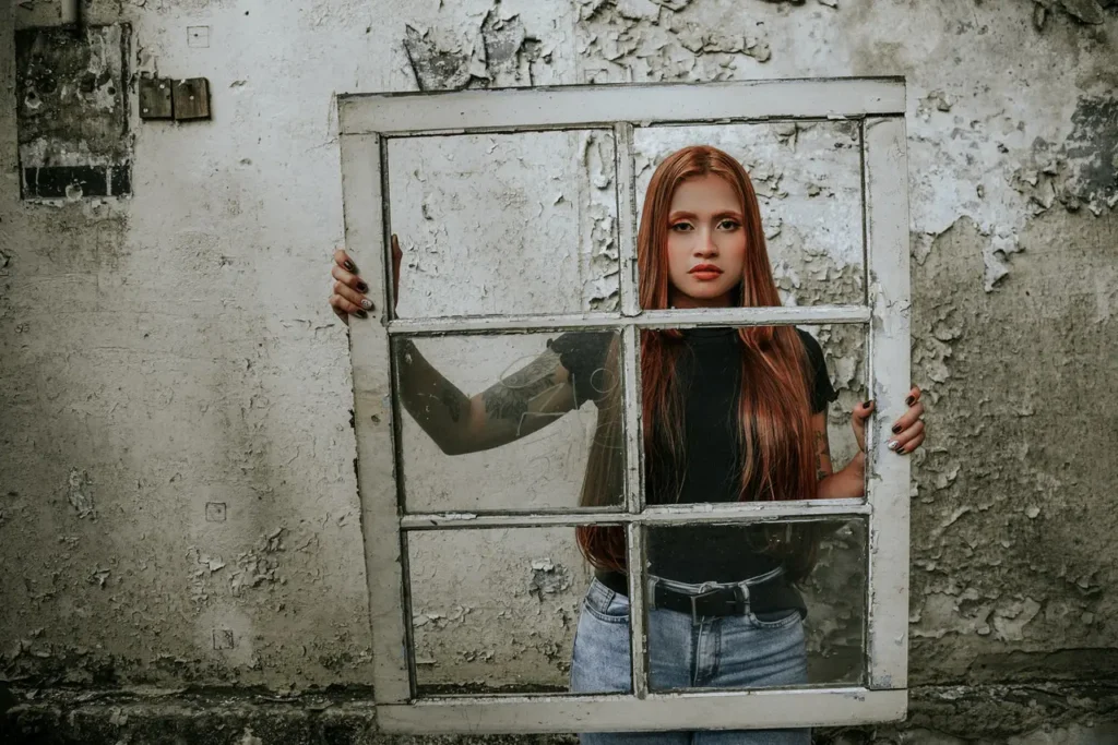 Woman with Wooden Window frame past its best replaeing Single Glazed Windows with Double Glazing