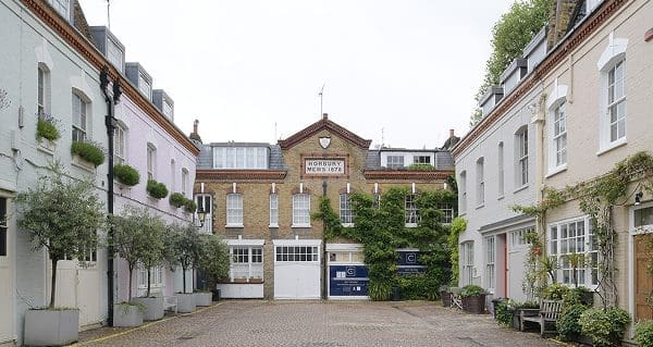 Historic mews building with cream and brick façades around a quiet courtyard, retrofitted with Gowercroft vacuum glazed timber windows. The windows retain a traditional appearance while improving the building’s energy efficiency.