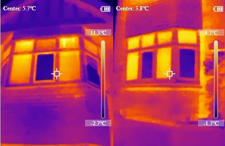 Side-by-side thermal imaging comparison of two windows, using purple, red, orange and yellow heat-map colours to show heat loss. The brighter yellow and orange areas indicate more heat escaping, while the darker purple areas suggest better insulation. The vacuum glazed window appears to show less heat escaping than the other window, demonstrating improved thermal performance.